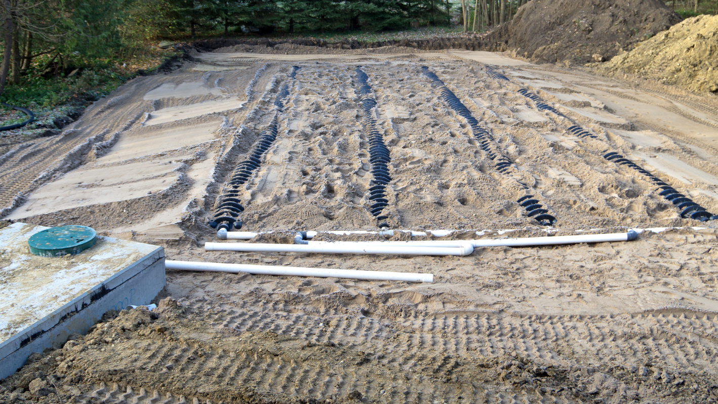 A dirt road with pipes laying on top of it