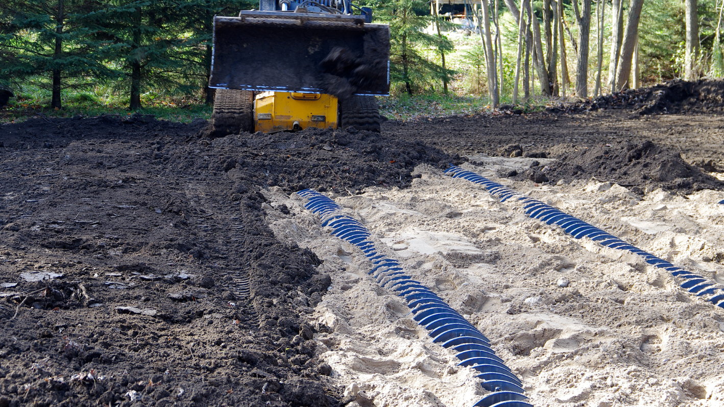 A bulldozer digging through a field of dirt